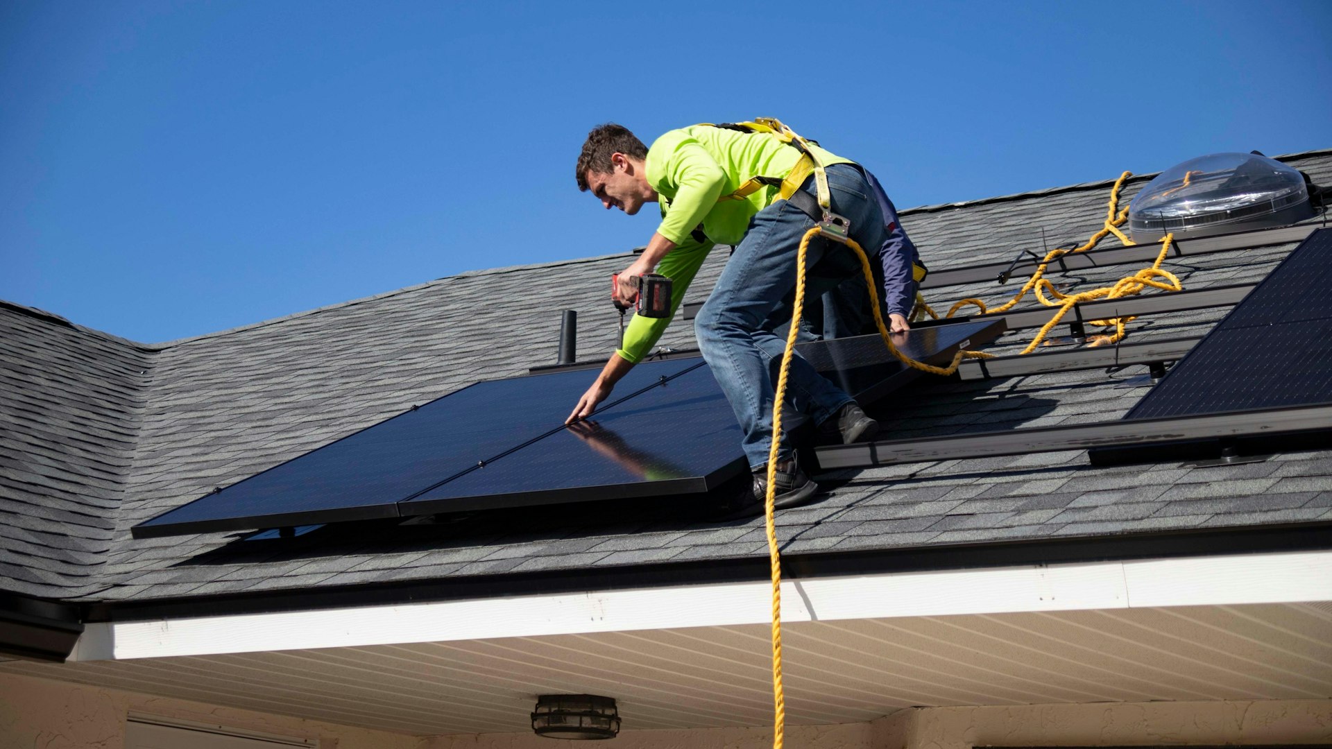 A person installing solar panels on a roof